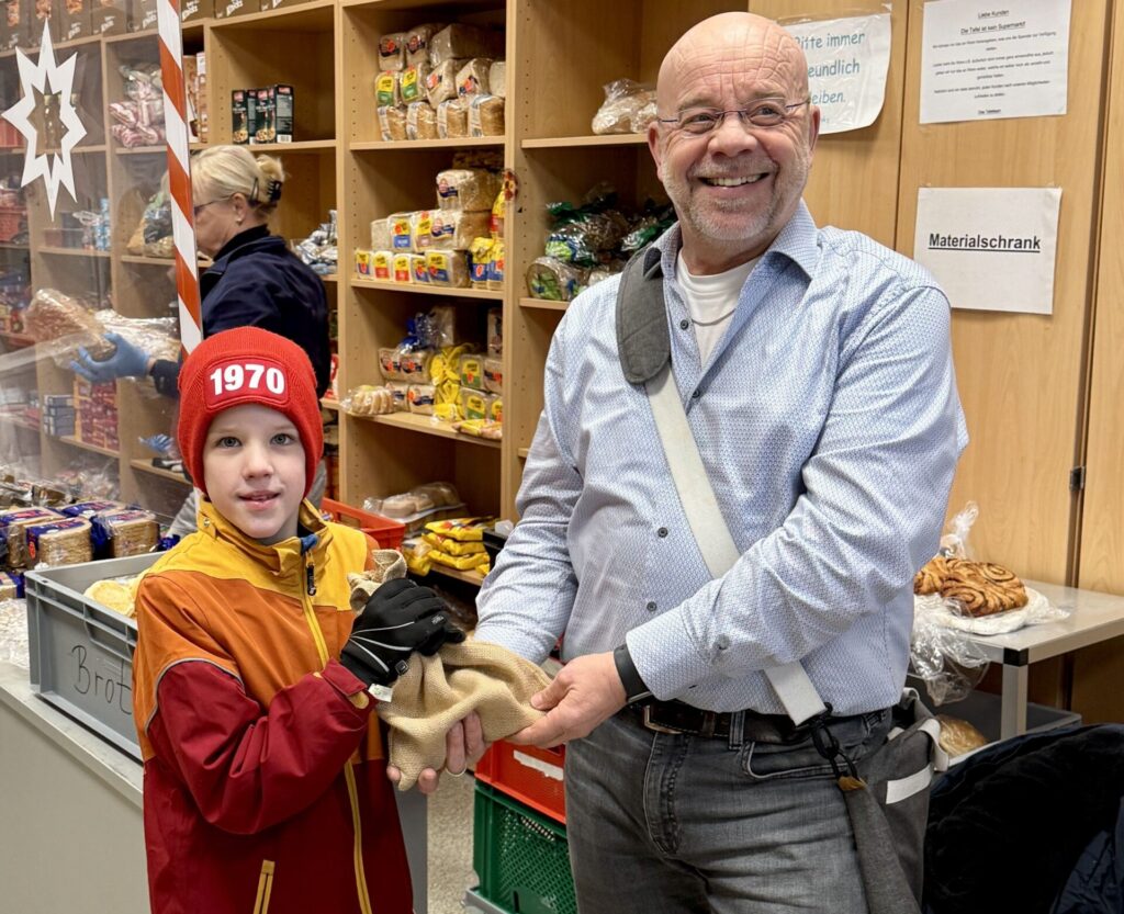 Johannes Lügering (r.) von der Ahauser Tafel freute sich über die Spende, die Felix mit seinem Tenorhorn in der Ahauser Fußgängerzone eingespielt hatte.
