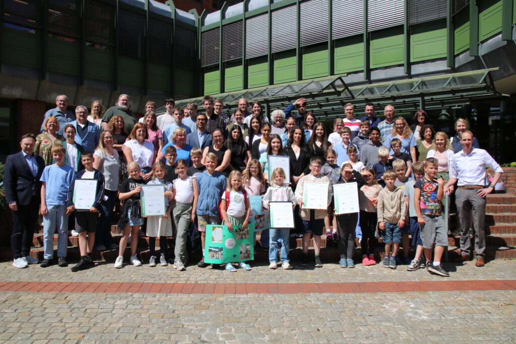 Gruppenbild zum "Klimaschutzpreis 2026": Die Schülerinnen und Schüler sowie Lehrkräfte aller prämierten Schulen, Landrat Dr. Kai Zwicker, die Jurymitglieder und Laudatoren freuen sich über die Preise und die vielen guten Ideen.