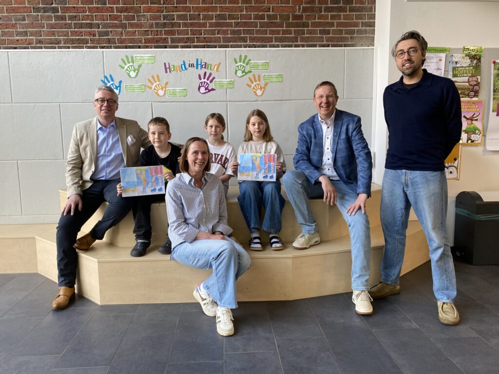 Marlon Barenbrügge, Annika Harmeling und Ella Krassenbrink präsentieren stolz ihre prämierte Collage, die im Herbst die 8000 Exemplare des Lions-Adventskalenders schmücken wird. Mit ihnen freuen sich die Schulleiterin Birgit Knauer (Mitte, vorne) und Kunstlehrer Benjamin Bode (rechts) von der Hand-in-Hand-Schule sowie Lions-Präsident Werner Ruppert (links) und Markus Tenwinkel (2. von rechts), der Verantwortliche für den Lions-Adventskalender