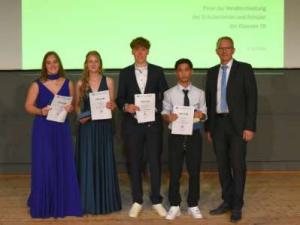 Die vier Klassenbesten (v.l.) Sophia Klein, Lina Robers, Johann Höing und Emir Çoktan wurden vom Schulleiter Stefan Wichmann mit einer Urkunde geehrt.